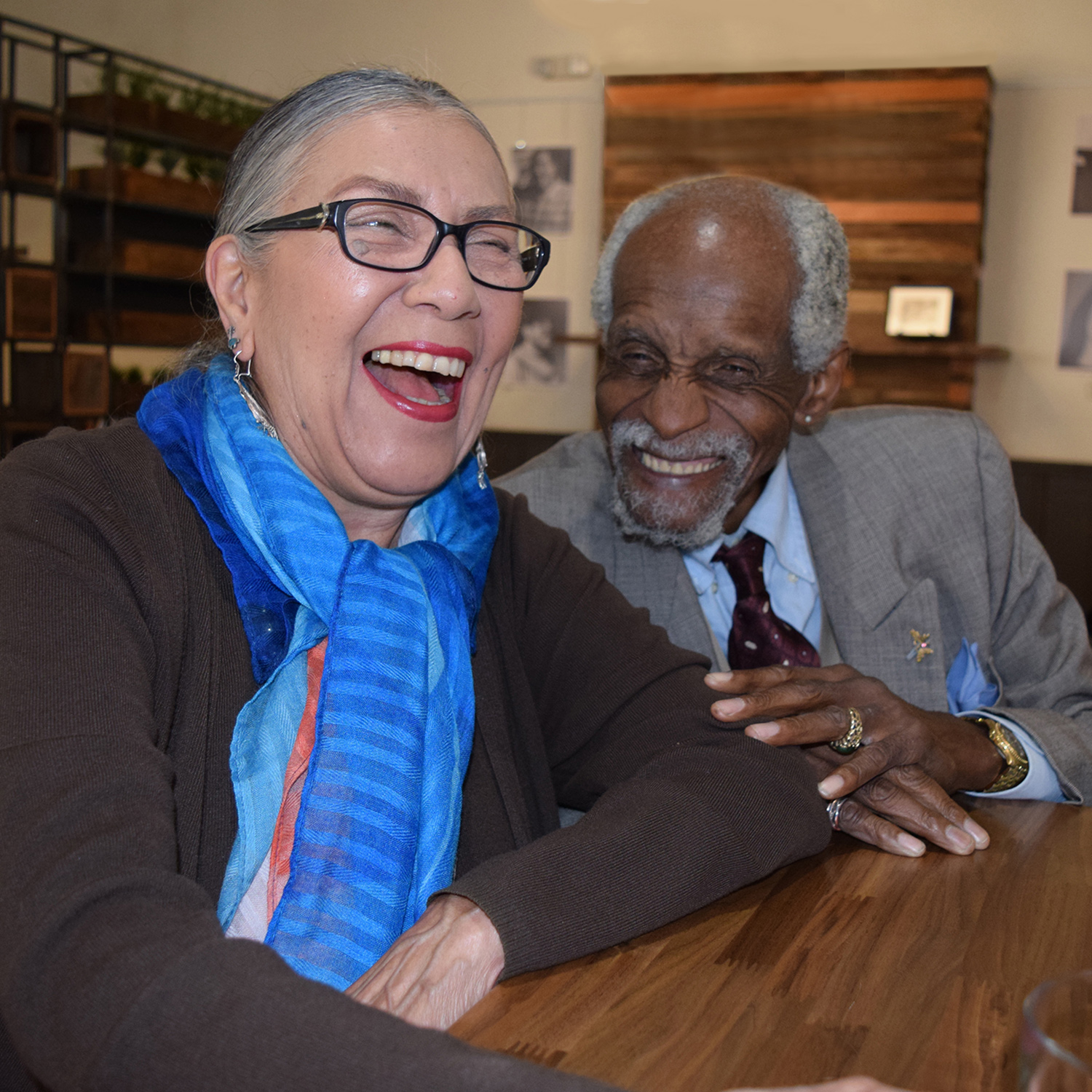 Two people sitting at a table share a laugh
