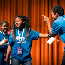 three children doing improv on a stage